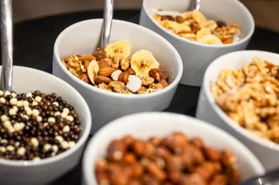 a group of white bowls filled with nuts and seeds at Hotel Hell in Ortisei