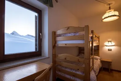 a bunk bed in a room with a window at Albergo Vezzana in Passo Rolle