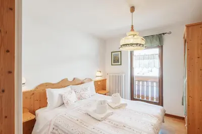 a bedroom with a bed with two cups on it at Albergo Vezzana in Passo Rolle