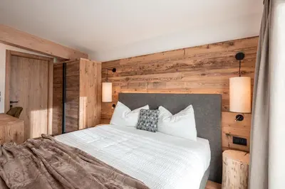 a bedroom with a large bed with wooden walls at Albergo Vezzana in Passo Rolle