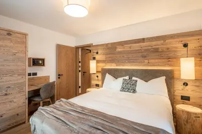 a bedroom with a bed with a wooden wall at Albergo Vezzana in Passo Rolle