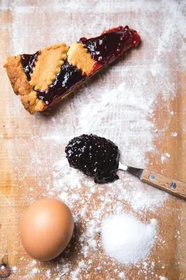a table with a pie and a spoon with powdered sugar at Albergo Vezzana in Passo Rolle