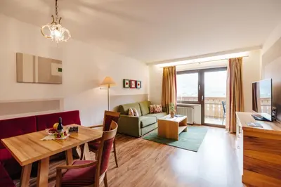 a living room and dining room with a dining table at Apartments Bachmair in Schenna