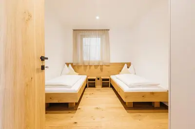 a room with two beds and a window at Egarter in Appiano sulla Strada del Vino
