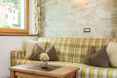 a living room with a couch and a table at Amonit - Your Dolomites Home in Selva di Val Gardena
