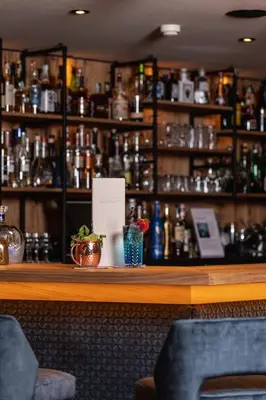 a bar in a restaurant with a counter with at Hotel Sun Valley in Selva di Val Gardena