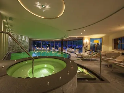 a pool in a hotel room with a hot tub at Hotel Sun Valley in Selva di Val Gardena