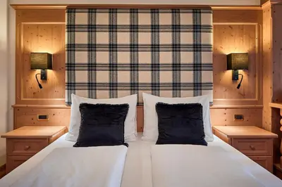 a bedroom with a white bed with two pillows at Hotel Des Alpes in La Villa