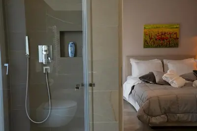 a bathroom with a shower and a bed in a room at Residence Villa Hedy in Merano