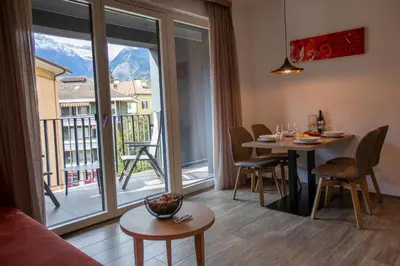 a living room with a table and chairs and a large window at Residence Villa Hedy in Merano