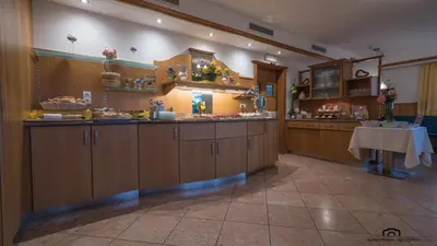a large kitchen with wooden cabinets and a table at Kreuzstein Bed&Breakfast in Appiano sulla Strada del Vino