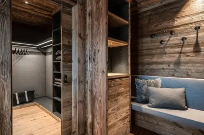 a walk in closet with wood paneling and a bench at Chalet Roenn in Colfosco