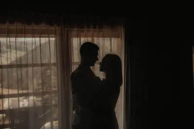 a bride and groom standing in front of a window at Chalet Roenn in Colfosco