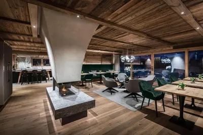 a dining room with a fireplace and tables and chairs at Chalet Roenn in Colfosco