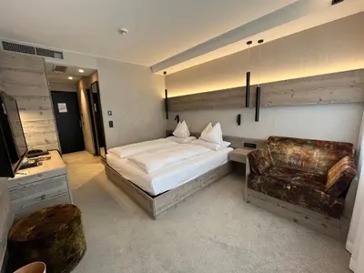 a bedroom with a bed and a couch and a chair at Bonfanti Design Hotel in Chienes