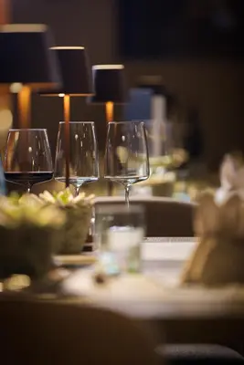 three wine glasses sitting on a table with food at Bonfanti Design Hotel in Chienes
