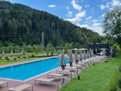 a swimming pool with lounge chairs and umbrellas at Bonfanti Design Hotel in Chienes