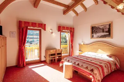 a bedroom with a bed and a window at Albergo Eden in Fiera di Primiero