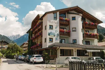 a hotel building with cars parked in front of it at Albergo Eden in Fiera di Primiero