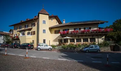 a large building with cars parked in front of it at Gasthof Zur Sonne in Laion