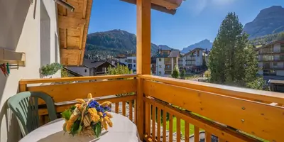 a balcony with a table and a view of a city at Garnì Lasteis B&B - apartments in La Villa