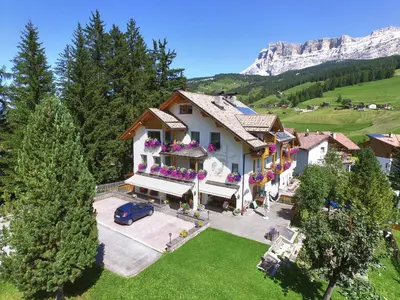 an aerial view of a house in the mountains at Garnì Lasteis B&B - apartments in La Villa