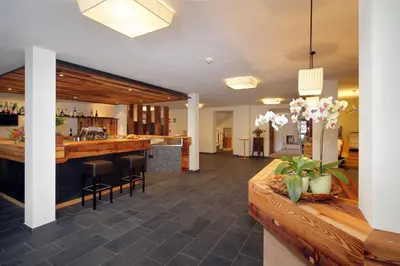 a lobby with a bar in a house at Vitalhotel Rainer in Ultimo