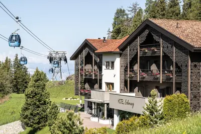 a building with a gazebo and a ski lift at Hotel Schmung in Alpe di Siusi