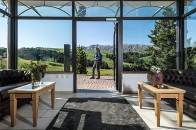 a woman standing in the window of a building at Hotel Schmung in Alpe di Siusi