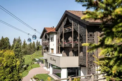 a building with a gazebo and a ski lift at Hotel Schmung in Alpe di Siusi