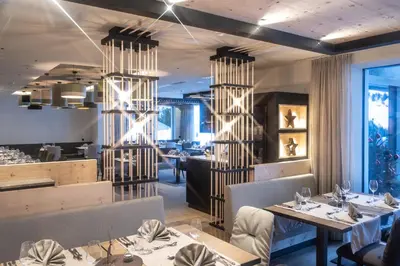 a restaurant with tables and chairs and a dining room at Hotel Schmung in Alpe di Siusi