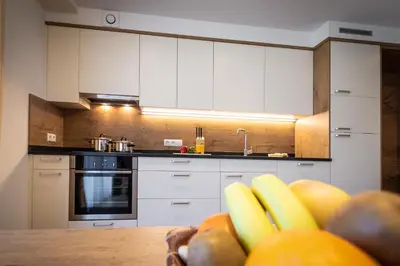 a kitchen with white cabinets and a bowl of fruit at Chalet Morin in San Martino in Badia