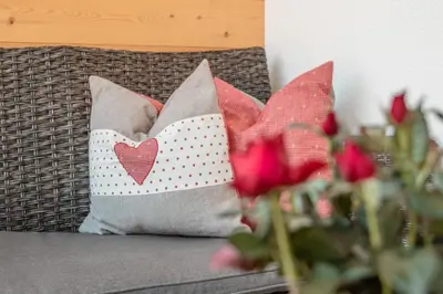 a bunch of pillows on a couch with red roses at Chalet Morin in San Martino in Badia