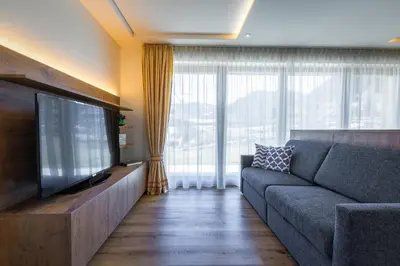 a living room with a couch and a flat screen tv at Chalet Morin in San Martino in Badia