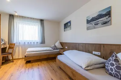 a hotel room with two beds and a desk at Chalet Morin in San Martino in Badia