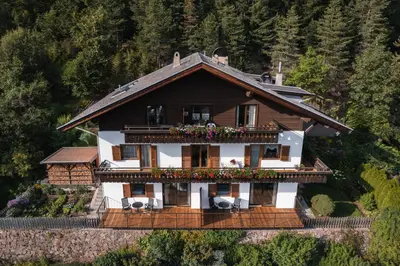 a house on a hill with a balcony at Apartments Kranebitt in Eggen