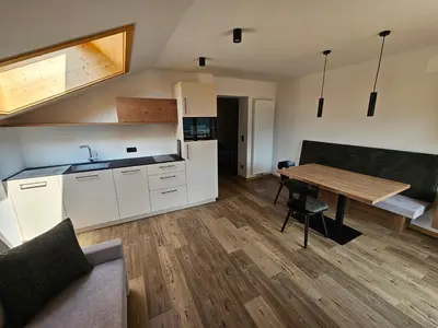 a kitchen and dining room with a wooden table at Apartments Kranebitt in Eggen