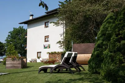 two benches sitting in the grass in front of a building at Piccolo Orso Bruno in Cavareno