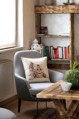 a chair with a pillow on it in a living room at Piccolo Orso Bruno in Cavareno