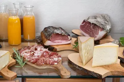 a table with different types of meats and cheese at Piccolo Orso Bruno in Cavareno