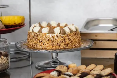 a cake on a plate on a counter with cookies at Piccolo Orso Bruno in Cavareno