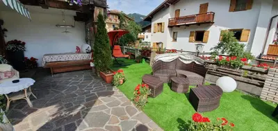 an outdoor patio with chairs and tables and flowers at Inter Hotel B&B in Vigo di Fassa