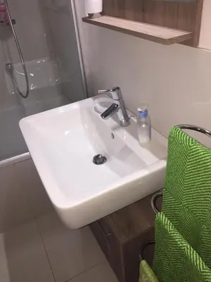 a white sink in a bathroom with a shower at Appartamento Ligeia in Bolzano