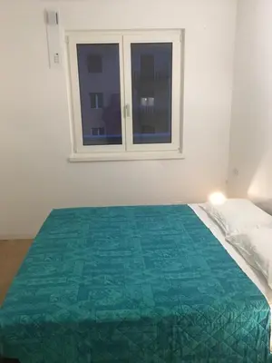 a white bedroom with a bed with a window at Appartamento Ligeia in Bolzano