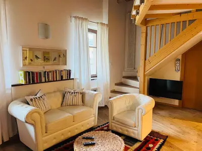 a bedroom with a bed with white sheets and wooden ceilings at Casanemone in Tesero