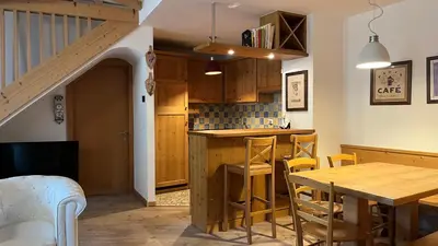 a living room with a couch and a tv at Casanemone in Tesero
