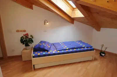 a bedroom with a bed in a room with wooden ceilings at Haus Hofer *** in Andrian