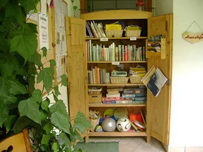 a book shelf filled with books and baskets at Haus Hofer *** in Andrian