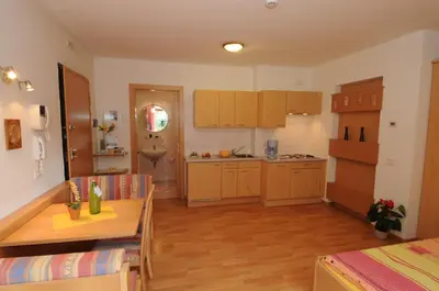a kitchen with wooden cabinets and a table in a room at Haus Hofer *** in Andrian