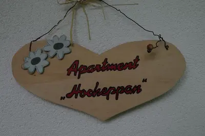 a wooden heart shaped sign hanging on a wall at Haus Hofer *** in Andrian